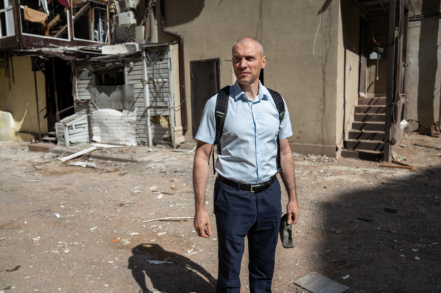 Denis Masliy, of the regional prosecutor's office, in the courtyard of a building damaged by a missile strike