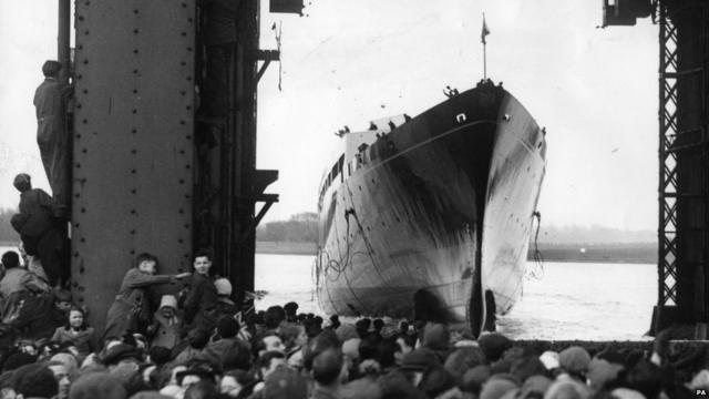 Черно-белая фотография, корабль на воде и радостные толпы