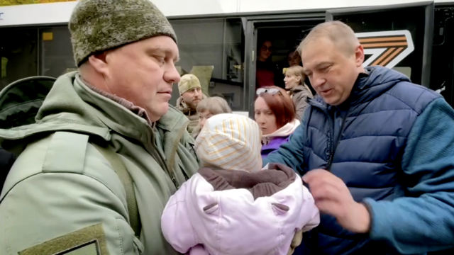 Igor Kastyukevich (left) with children being loaded onto a bus