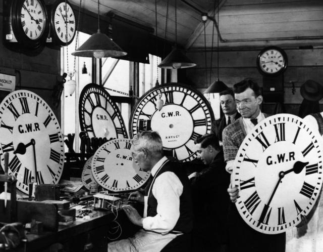Группа сотрудников Большой западной железной дороги чинят настенные часы. 30-е годы