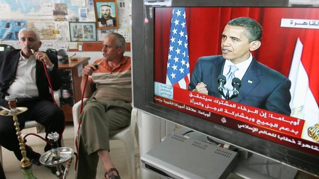 Палестинцы курят кальян и слушают речь президента Обамы в каирском университете 4 июня 2009 года
