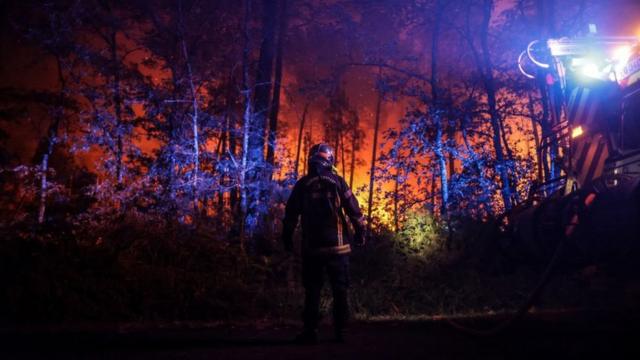 Пожарный недалеко от Белин-Белье, юго-запад Франции, ночью, 11 августа 2022 года.
