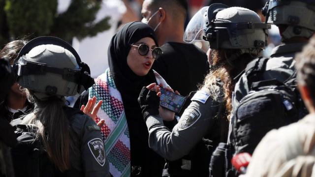 Israeli policewoman talks to a woman next to the Damascus Gate of Jerusalem's Old City (15 June 2021)