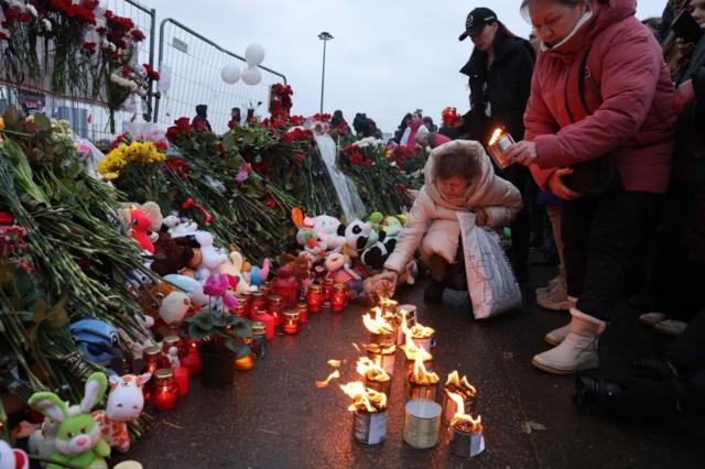 Des personnes déposent des fleurs devant l'hôtel de ville de Crocus à Moscou.