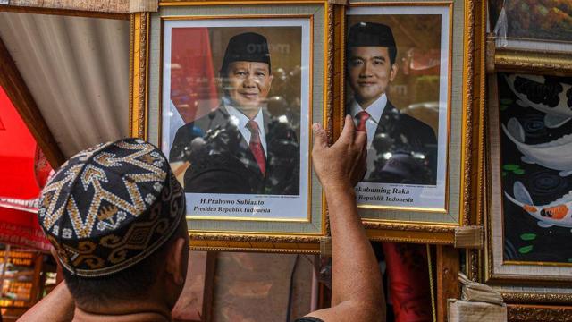 Pedagang menata foto pasangan Prabowo-Gibran sebagai Presiden dan Wakil Presiden 2024-2029 di kawasan Pasar Baru, Jakarta, Selasa (23/4/2024).