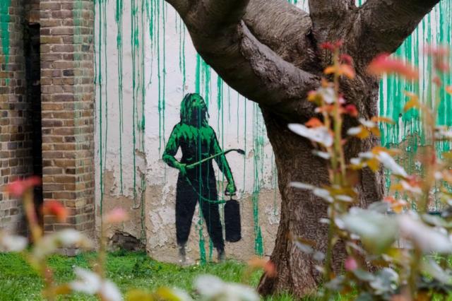 Часть граффити Бэнкси — девочка с баллоном инсектицида и шлангом в руках