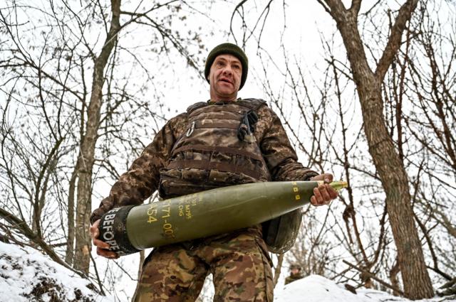 Украинский солдат с артиллерийским снарядом