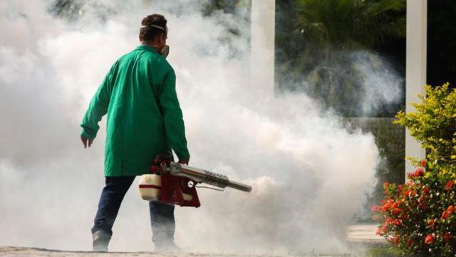 Homem aplicando fumacê