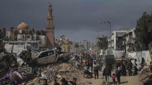 Palestiniens entourés par les décombres de bâtiments détruits après une opération militaire israélienne à Khan Younis, dans le sud de la bande de Gaza, le 6 mars 2024.