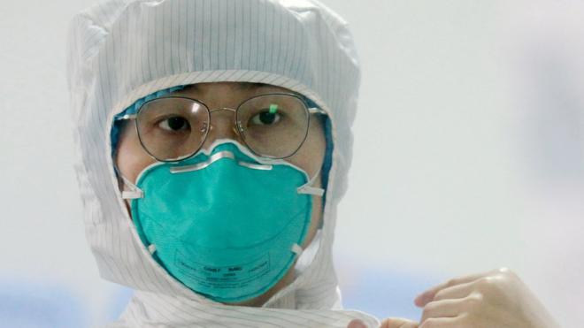Медсестра готовится войти в палату с больными коронавирусом в провинции Янчжоу