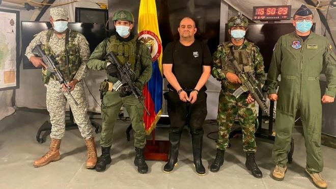 Armed Colombian soldiers show handcuffed drug lord Dairo Antonio Úsuga, known as Otoniel (centre). Photo: 23 October 2021