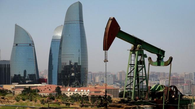 Нефтяная вышка на фоне небоскребов в Азербайджане