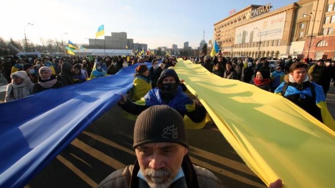 People carry blue and yellow stripes of fabric in the national colours during the Unity March in Kharkiv, northeastern Ukraine. (Photo credit should read Vyacheslav Madiyevskyy/ Ukrinform/Future Publishing via Getty Images)