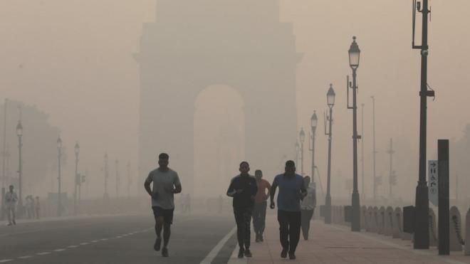 Люди бегут сквозь смог в Дели