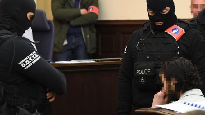 Salah Abdeslam sits surrounded by Belgian special police officers in the courtroom at the Palais de Justice courthouse in Brussels.