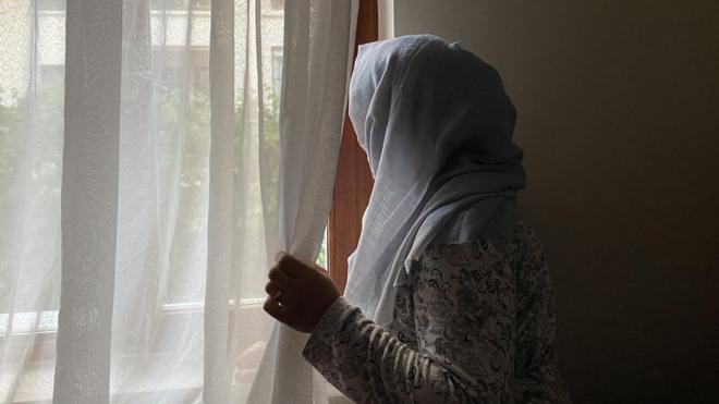 camdan bakan bir afgan kadın