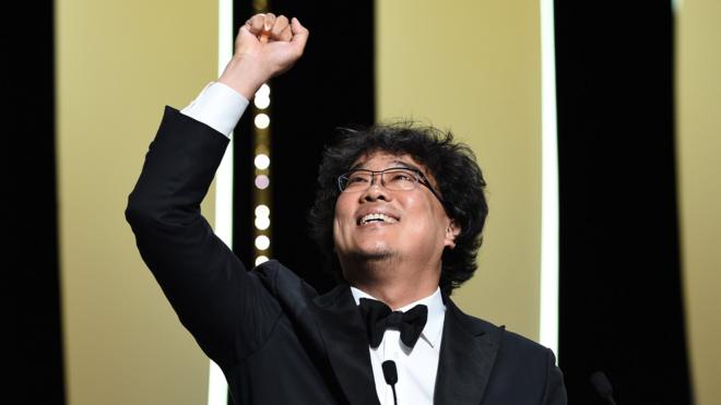 Director Bong Joon-Ho (L) reacts after winning the Palme d"Or award for "Parasite" on stage during the Closing Ceremony of the 72nd annual Cannes Film Festival on May 25, 2019 in Cannes, France.