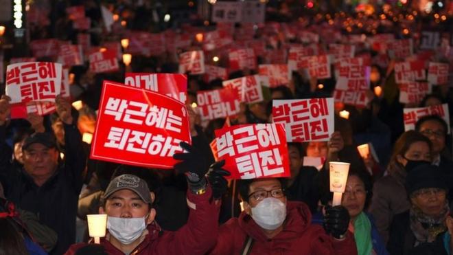 Жители Южной Кореи вышли на улицы, требуя отставки президента, с плакатами "Пак Кын Хе, уходи".