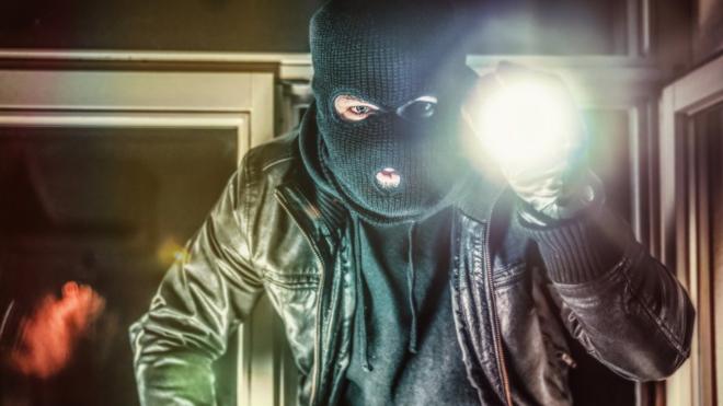 Masked burglar holding torch