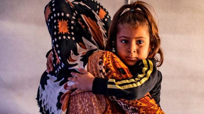 Displaced woman and child in Tuwaynah, north-east Syria (file photo)