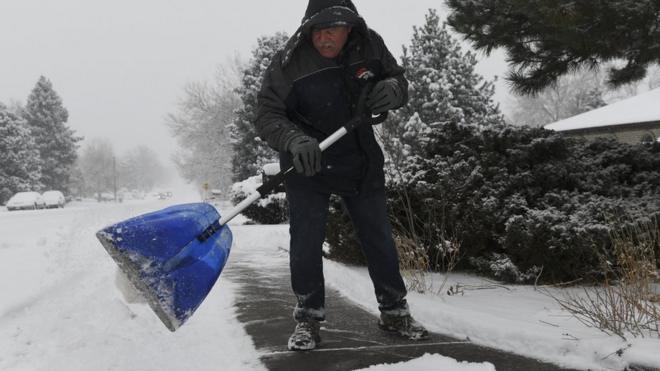 A man shovels snow near his home in Denver, Colorado