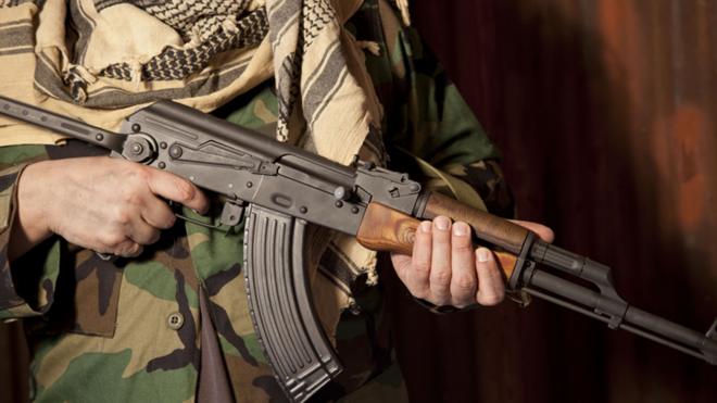 A file picture showing a close-up of a man's camouflage-clad mid-section, and a Kalashnikov rifle in his hands