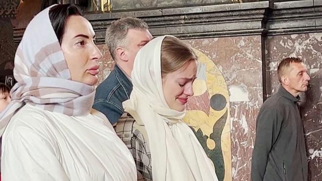 Девушка плачет во время пасхальной службы в Киеве