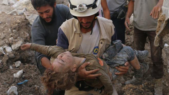 Спасатель с телом девочки, извлеченной из под обломков здания