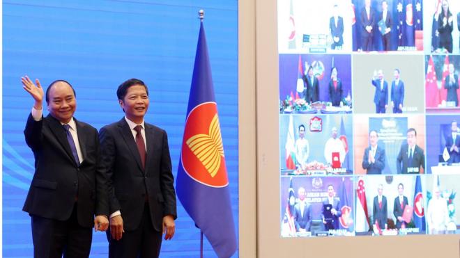 Vietnam"s Prime Minister Nguyen Xuan Phuc (L) and Minister of Industry and Trade Tran Tuan Anh (R) cheer after the virtual signing ceremony for the Regional Comprehensive Economic Partnership (RCEP) in Hanoi, Vietnam, 15 November 2020.