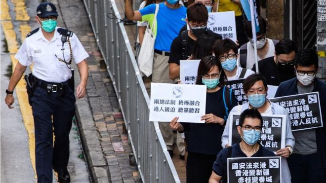 Возмущенные новым законом жители Гонконга прошли в пятницу маршем протеста