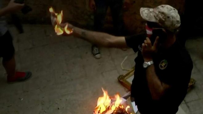 Протестующий в Ливане сжигает портрет президента