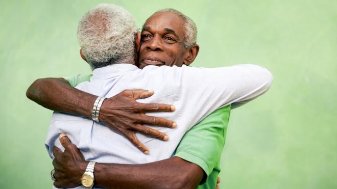 Two elderly men hugging