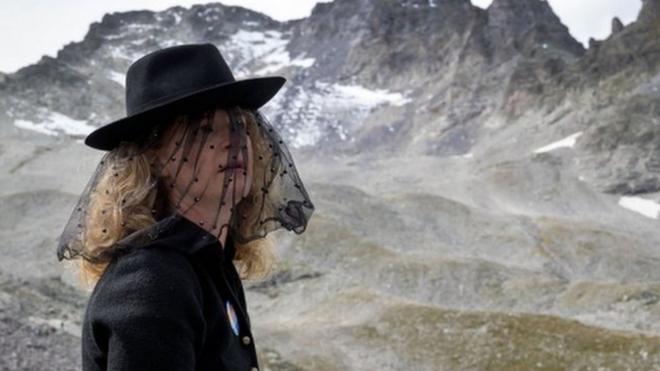 A woman takes part in a ceremony to mark the "death" of the Pizol glacier