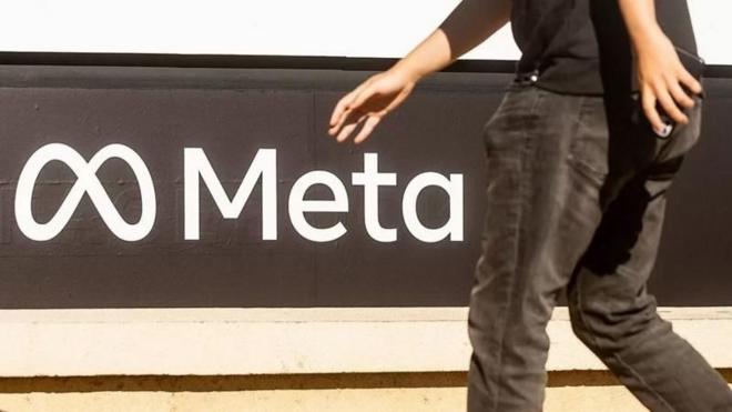 Pessoa passa em frente a letreiro da Meta