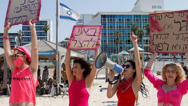 Девушки в купальниках протестуют на пляже