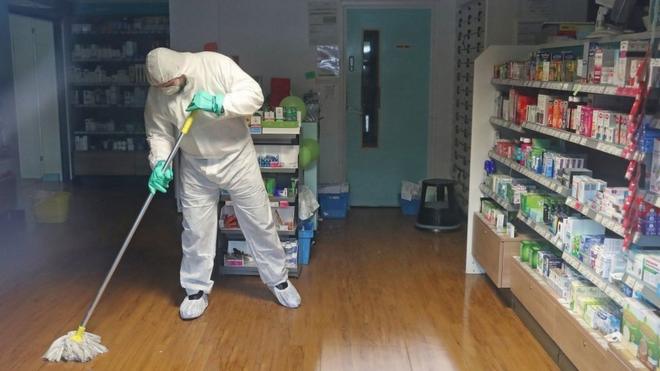 A man in protective clothing cleaning the County Oak medical centre