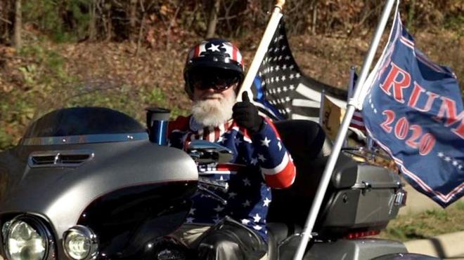 Мужчина на мотоцикле, с флагами "Трамп 2020"