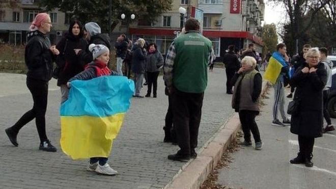 Girl in Kherson holds Ukrainian flag
