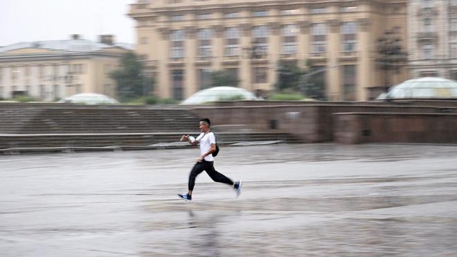 Мужчина бежит под дождем