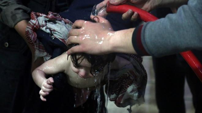 A child is washed with a hose at a hospital in Douma, eastern Ghouta in Syria, after a suspected chemical attack (7 April 2018)