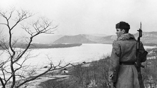 Советский пограничник на правом берегу Уссури. Напротив - остров Даманский (1969 год)
