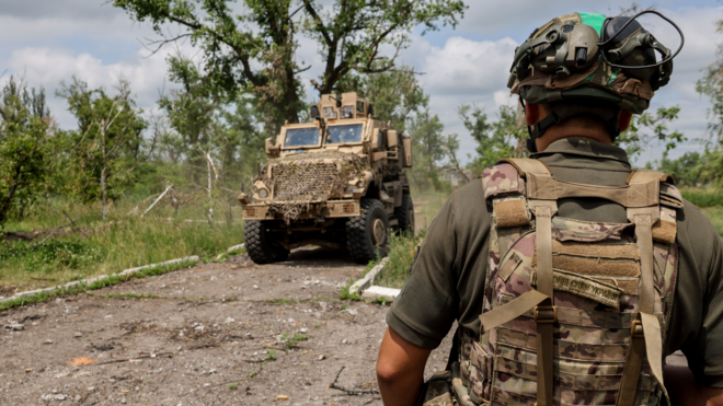 Український солдат на тлі бронемобіля