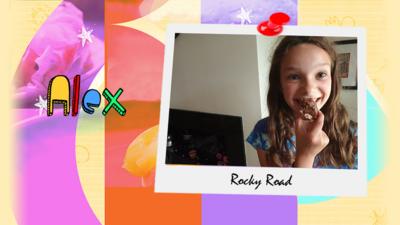 A girl shows a plate of the rocky road brownies that she has made.