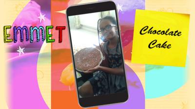 A girl (Emmet) holding a huge plate of chocolate cake, a round chocolately disk with hundred and thousands on it.