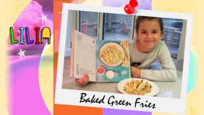 A little girl (Lilia) smiling and with a plate containing green baked fries and Tilly's recipe book.