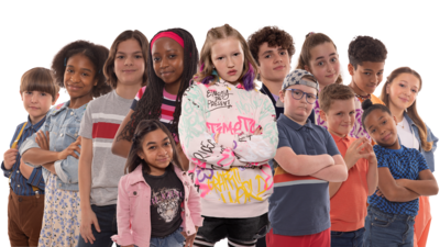 The cast of The Dumping Ground lined up back-to-back smiling to camera