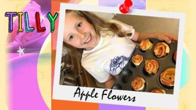 A young girl called Tilly shows the camera a muffin tin filled with apple flowers about to go into the oven.