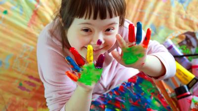 Little girl with painted hands smiling