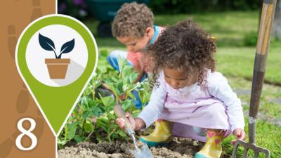 A little boy and a little girl digging in a garden patch