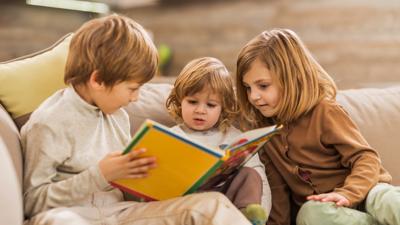 Three siblings reading together